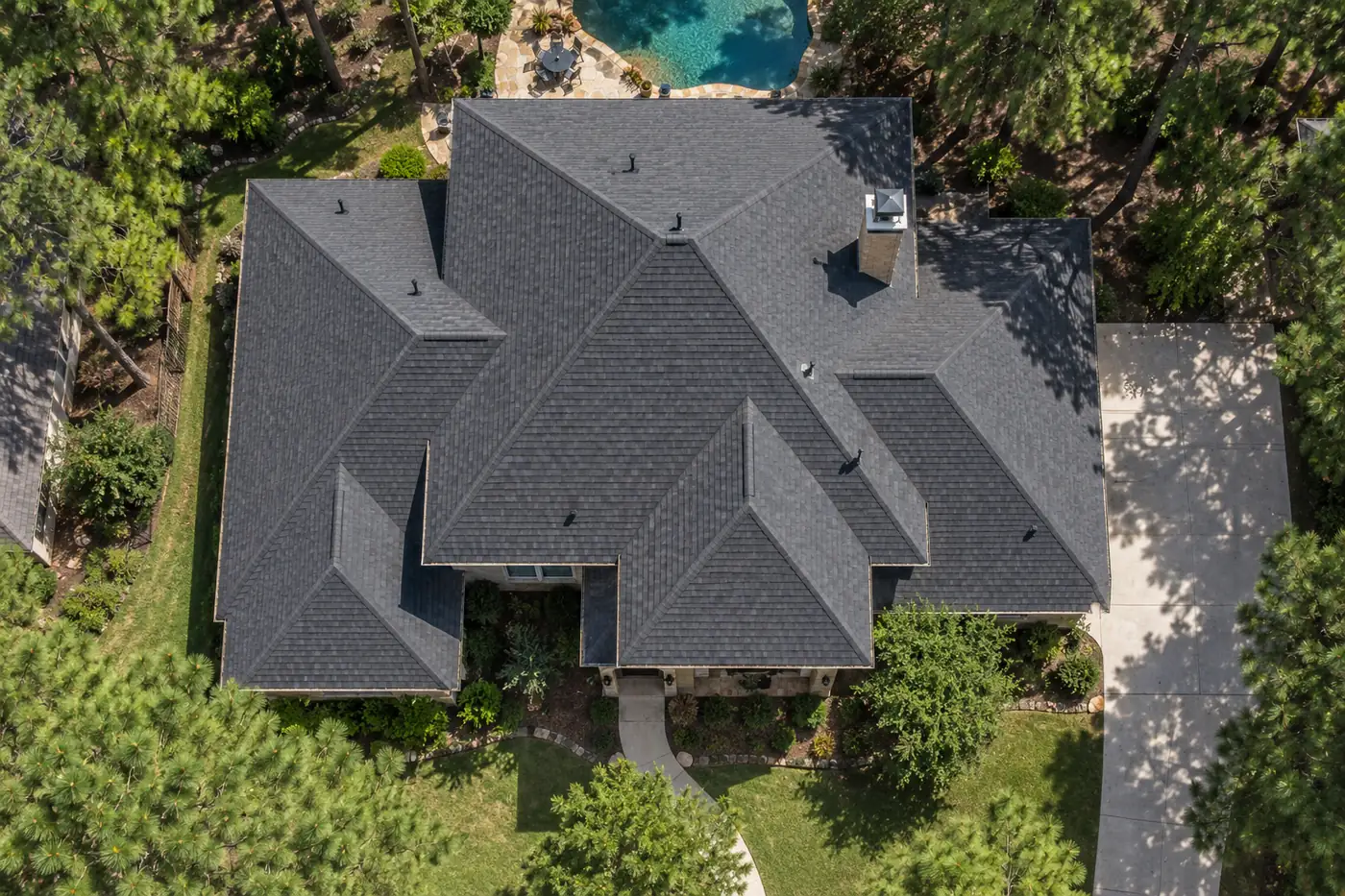 Top-down view of a hip roof with dark architectural shingles